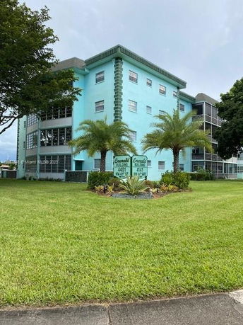 Front view of a turquoise multi-story residential building.