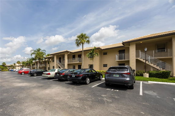 Parking area in front of a two-story building with external staircases.