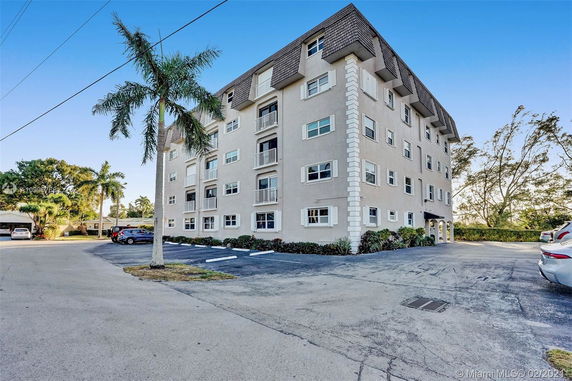 Front view of a multi-story residential building with a mansard roof.