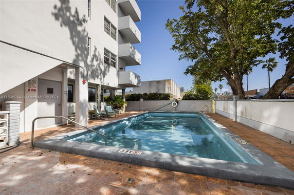 Outdoor swimming pool adjacent to a multi-story building.