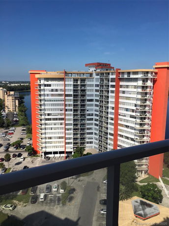 Panoramic view of a large apartment building with red and beige accents from a high vantage point.