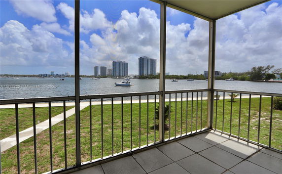 View of surrounding area with water and distant buildings from a balcony.