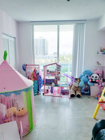 Indoor playroom with toys and large glass windows.