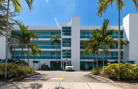 Front view of a modern multi-story building with balconies and a central entrance.