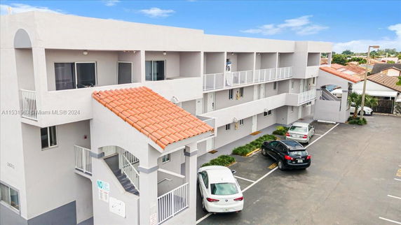 Front view of a multi-story building with a flat roof and exterior staircases.