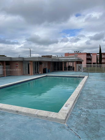 Outdoor swimming pool area in front of a building.