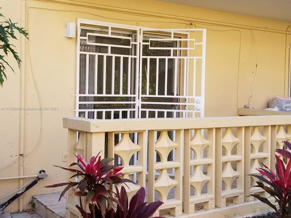 Front view of a house with a decorative metal gate and railing.
