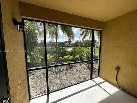 Patio view of surrounding area with palm trees and distant houses.