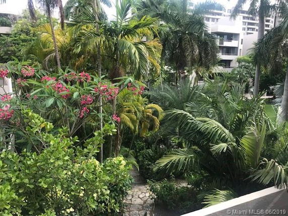 View of lush greenery and tropical plants surrounding a residential building.