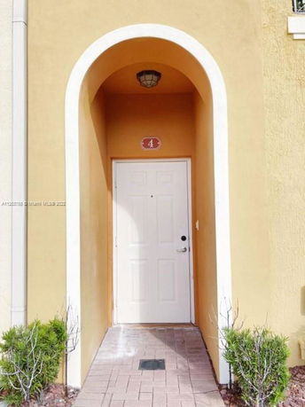 Front view of a house entrance with an arched doorway and number 4.