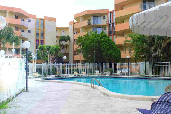 Outdoor swimming pool area adjacent to a residential building.