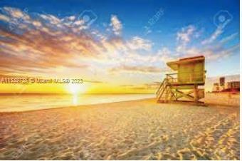 Beach scene with a lifeguard tower and sunset.