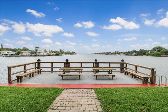 Viewing platform with benches and a table overlooking a body of water.