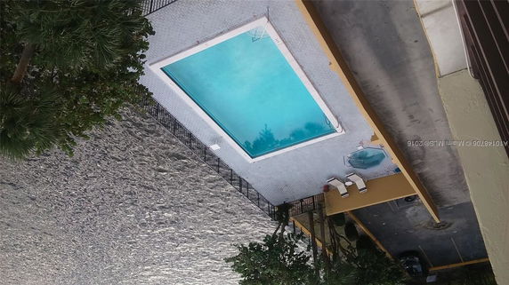 View of a rooftop with a swimming pool and lounging area.