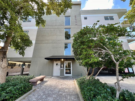 Front view of a multi-story residential building with a gated entry.