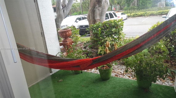 Outdoor area with a hammock and visible parking lot.