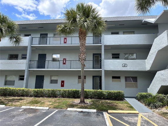 Front view of a three-story apartment building with balconies.