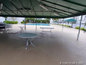 Open outdoor area with tables and a view of a swimming pool.