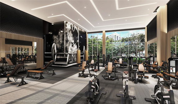 Interior view of a modern gym with exercise equipment and large windows.
