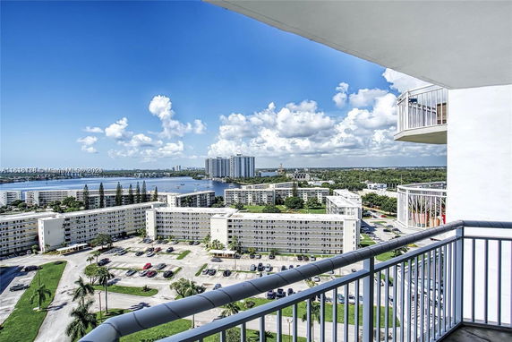 Panoramic view from a high-rise building balcony overlooking a river and surrounding apartment complexes.
