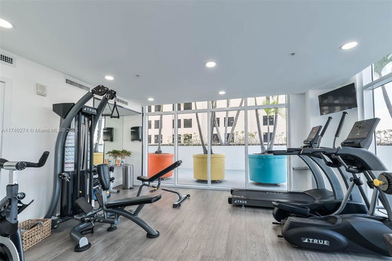Gym area with exercise equipment including treadmills and weight machines.