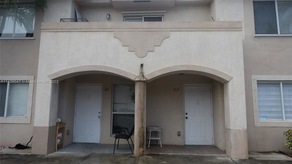Front view of a two-story building with two entrance doors and a small balcony.