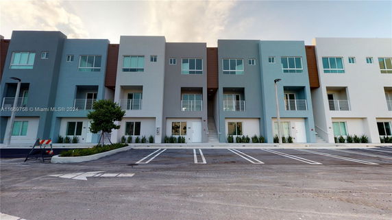 Front view of a modern multi-story building with balconies.