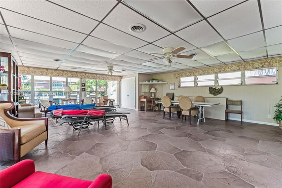 Indoor recreational area with seating and folding chairs.