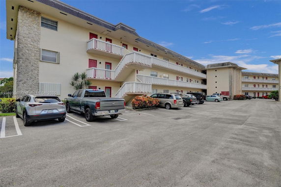 Outdoor parking area in front of a multi-story building.