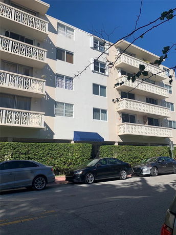 Front view of a multi-story apartment building with balconies.