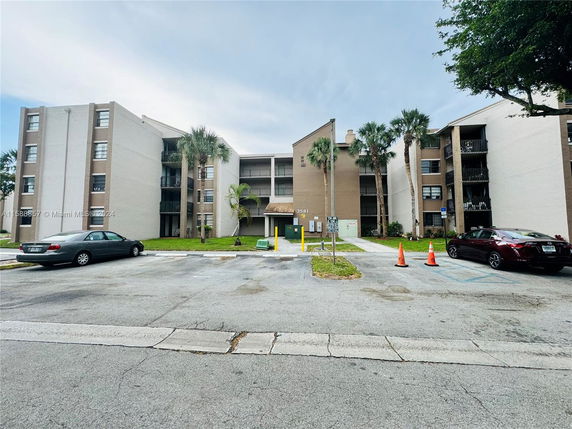 Front view of a multi-story apartment building with multiple balconies.