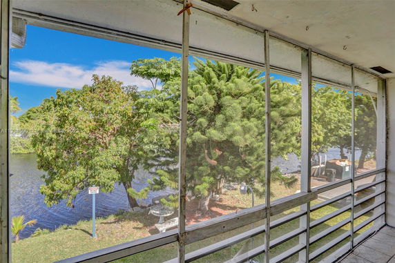 View from a screened porch overlooking a river and trees.