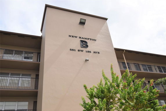 Front view of a multi-story building with balconies and signage.