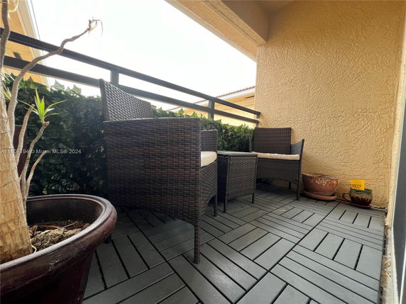 Outdoor patio area with wicker chairs and potted plants.