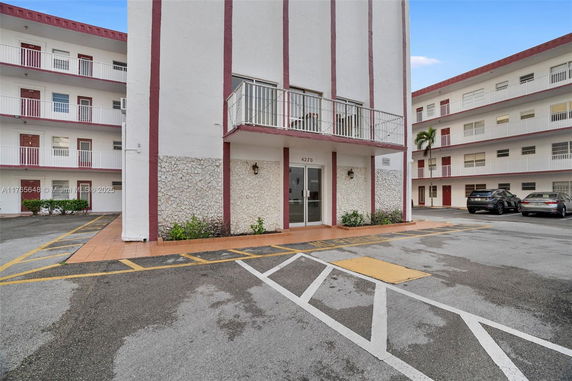 Front view of a multi-story building with a parking area.