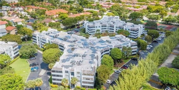 Aerial view of a large, multi-story apartment complex with surrounding landscaped areas and parking.