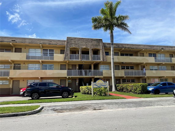 Front view of a three-story apartment building with balconies.