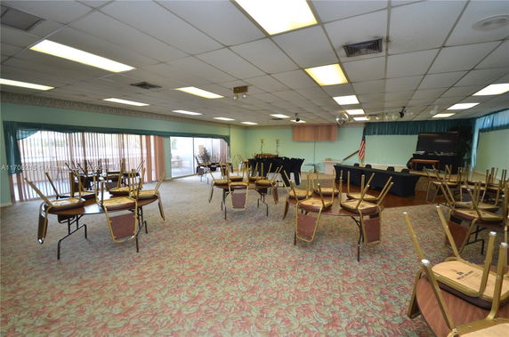 Indoor recreational area with tables and chairs arranged for events or activities.