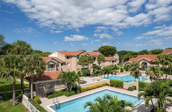 Outdoor area featuring a swimming pool surrounded by residential buildings with red-tiled roofs.