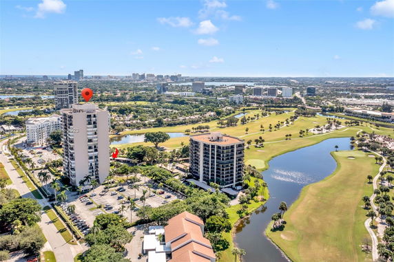 Panoramic view of buildings and golf course with surrounding landscape.
