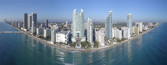Panoramic view of a coastal city with numerous high-rise buildings along the shoreline.