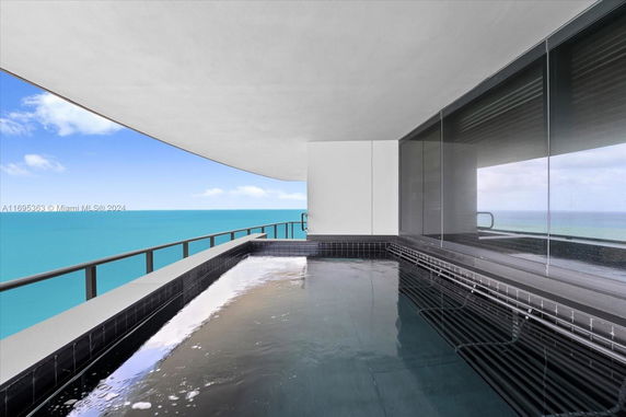Outdoor balcony with a pool overlooking the ocean.