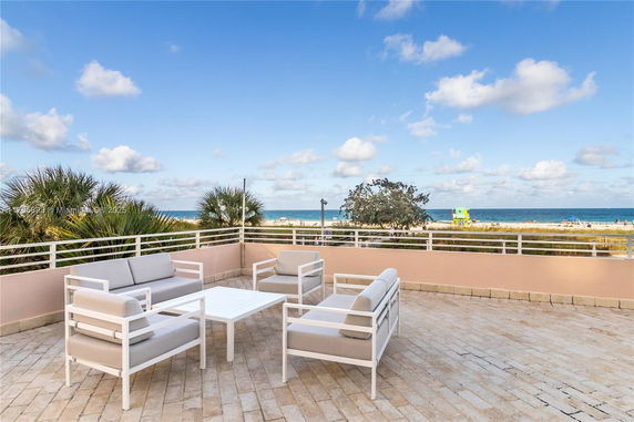Rooftop patio with seating overlooking the ocean.