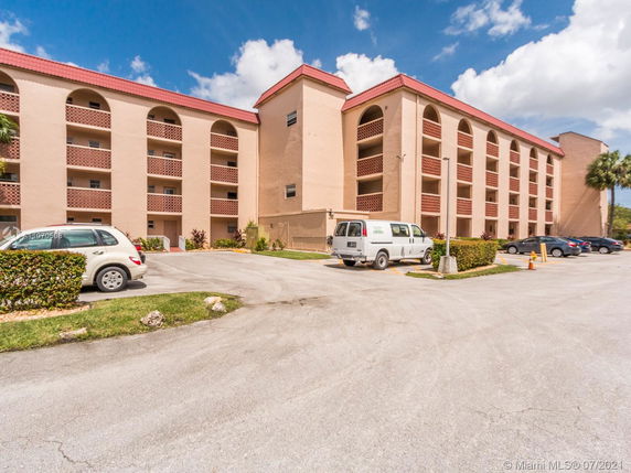 Front view of a multi-story building with outdoor parking area.