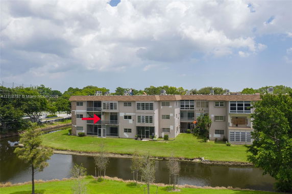 Front view of a multi-story apartment building near a water body.