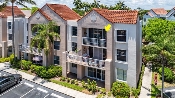 Front view of a multi-story residential building with balconies and red tile roofing.