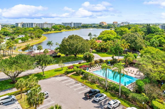 Aerial view of a scenic area with a lake, trees, and a swimming pool.
