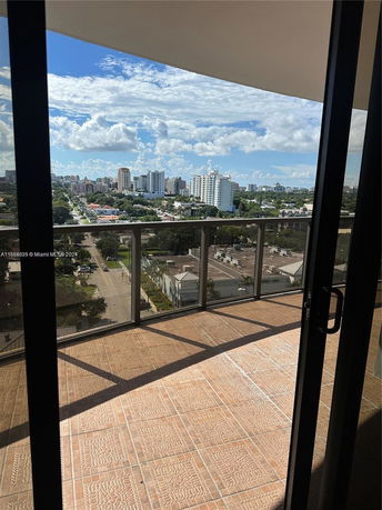 Panoramic view from a building balcony showing a cityscape.