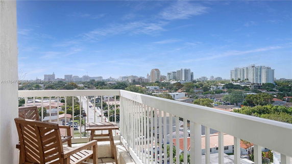 View of surrounding cityscape from a building balcony with chairs.