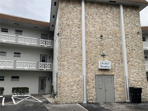 Front view of a multi-story building with stone facade and balconies.